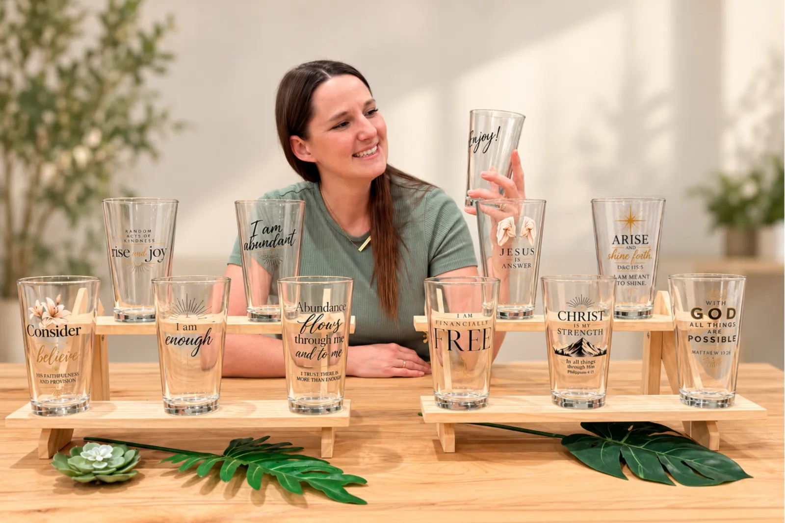Kira with a full display of affirmation pint glasses — Drink Your Affirmations